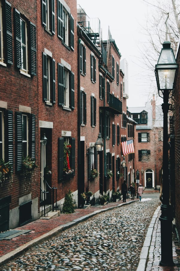 a sloped cobblestone alley with red brick buildings